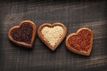 Chenopodium quinoa - White, red and black quinoa seeds in three heart-shaped bowls