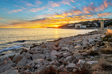 Sunset view from the Plage de la Grande Mer beach towards the Phare de Cassis lighthouse along the French Riviera coastline at the seaside village of Cassis, France.