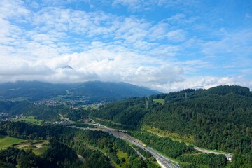 Obraz premium Clouds drift over Innsbruck, a city nestled in the Austrian Alps