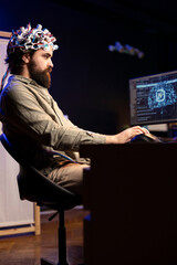 Programmer using EEG headset translating thoughts into PC commands using brainwave signals. Man...