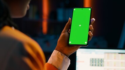 Student uses greenscreen on phone layout while she examines cash plan software for economy course research. Girl learning about expenses and earnings, looks at blank copyspace. Camera A.