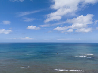 Blue ocean surface under sky with white clouds