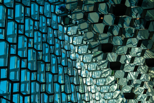 Modern building facade with hexagonal glass windows reflecting sky