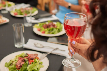 At a lively nightclub, people are enjoying wine and socializing in a chic ambiance