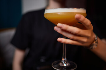 Bartender pours pink cocktail into martini glass with flair