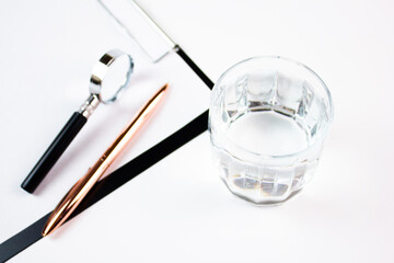 Drinking water in a glass next to the tablet, magnifying glass and pen concept of expertise, water analysis. Clean drinking water.