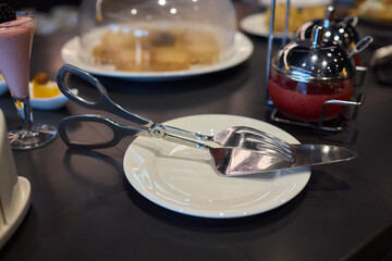An elegant display of a cutlery set and a dessert server arranged on a dining table