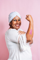 Afro-Latina breast cancer survivor with a positive attitude and a pink ribbon painted on her arm.
