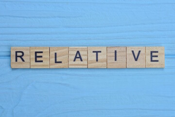 word relative made from wooden gray letters lies on a blue background