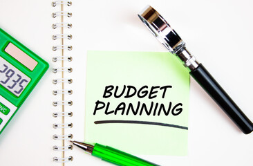 BUDGET PLANNING text,writing notes on a notepad with calculator and magnifying glass. Budget planning is a financial, economic concept, calculating expenses, profits, spending.