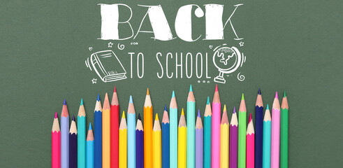 Many bright colorful pencils on green background