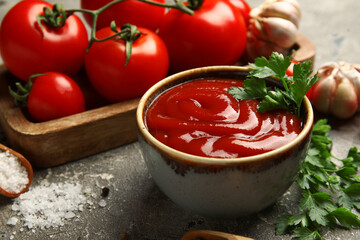 Bowl with tasty ketchup and fresh tomatoes on grunge background