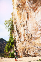 Mountain, rock climbing and people with rope by cliff for adventure, adrenaline or fitness challenge. Extreme sports, travel and man with instructor for harness gear for activity in nature on holiday