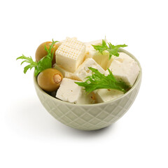 Bowl with tasty cut feta cheese, salad leaves and olives on white background