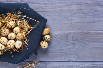 Quail eggs with fabric on blue wooden background