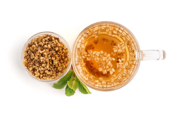 Glass cup of fresh buckwheat tea and mint on white background