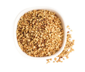 Bowl with raw buckwheat grains on white background