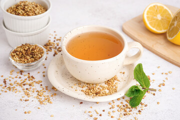 Cup of fresh buckwheat tea and mint on light background, closeup