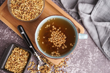 Cup of fresh buckwheat tea on grey grunge background