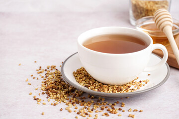 Cup of tasty fresh buckwheat tea on light background, closeup