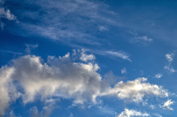 Obraz premium Background of Blue Sky with High Thin Cirrus Clouds and a Lower Layer of Cumulus Clouds.