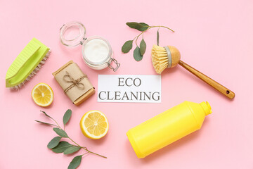 Composition with text ECO CLEANING, natural products and eucalyptus branches on pink background