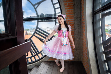 A young girl in a pink dress and bonnet poses gracefully inside a clock tower, blending historical charm with innocence.