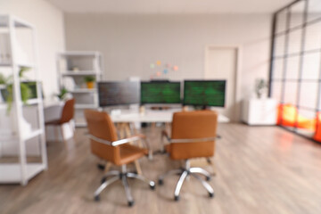 Blurred view of light office with programmer's workplace