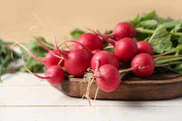 Cutting board with fresh radish on light wooden table, closeup
