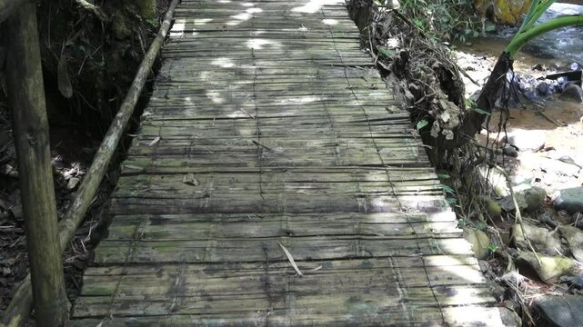 Puente artesanal en el bosque, sobr eun rio