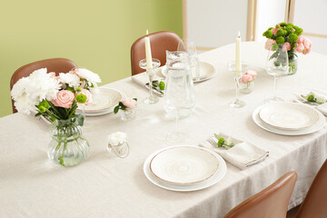 Festive table setting for wedding near green wall in dining room