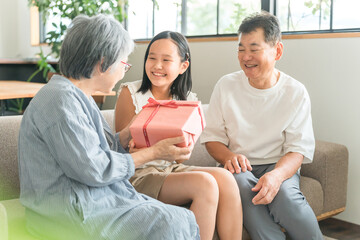 敬老の日・誕生日に祖母にプレゼントを渡す孫・女の子
