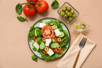 Plate of fresh vegetable salad with fork and ingredients on beige background