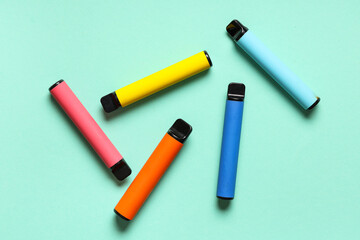 Different electronic cigarettes on turquoise background