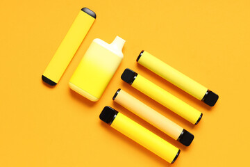 Different electronic cigarettes on orange background