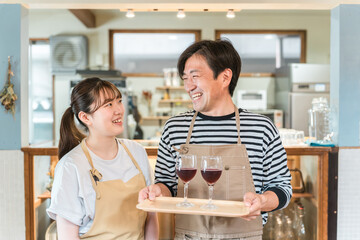 飲食店・バー・居酒屋・ワインバー・バル・ワインショップで赤ワインを持つ男女(ソムリエ・シェフ)
