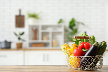 Basket with different fresh vegetables on wooden kitchen counter
