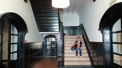 Obraz premium woman sitting on stairs with bag