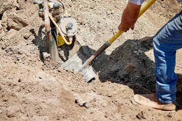 Construction worker digging out a buried propane tank