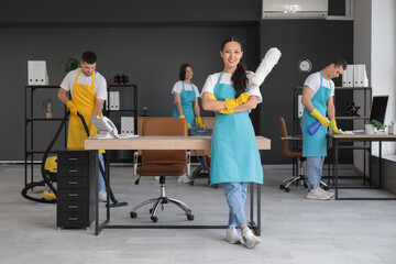 Female Asian janitor with pp-duster in office