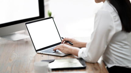 Closeup woman hand using laptop computer, sitting at desk office, mockup blank screen.