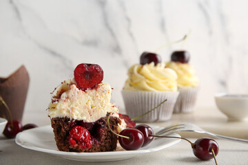 Plate with cut sweet cherry cupcake and berries on white background