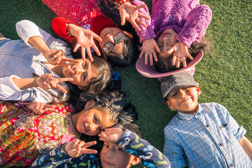 many happy children lying on the lawn of a park, concept of friendship