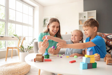 Cute little children with their mother sculpting from plasticine at home