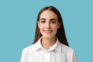 Young woman with diastema smiling on blue background, closeup