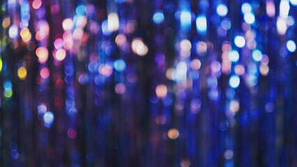 Bokeh light. Disco tinsel texture. Defocused holiday party festive decor. Iridescent blue purple pink color circles sparkle glitter pattern blur effect abstract background.
