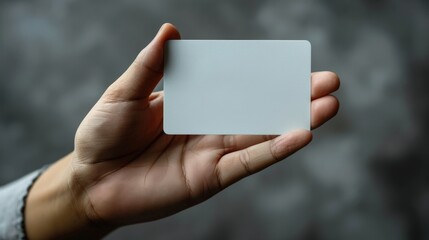 Close up photo of business man hand holding white blank credit card.