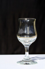 Stemmed wine glass on a white table against a black background