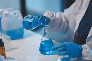 Fototapeta premium Group of dedicated scientist conduct chemical experiment in medical laboratory, carefully drop precise amount of liquid from pipette into test tube for vaccine drug or antibiotic development. Neoteric