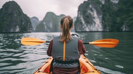 Vietnam's Natural Beauty. Back View of Woman Kayaking in Ha Long Bay